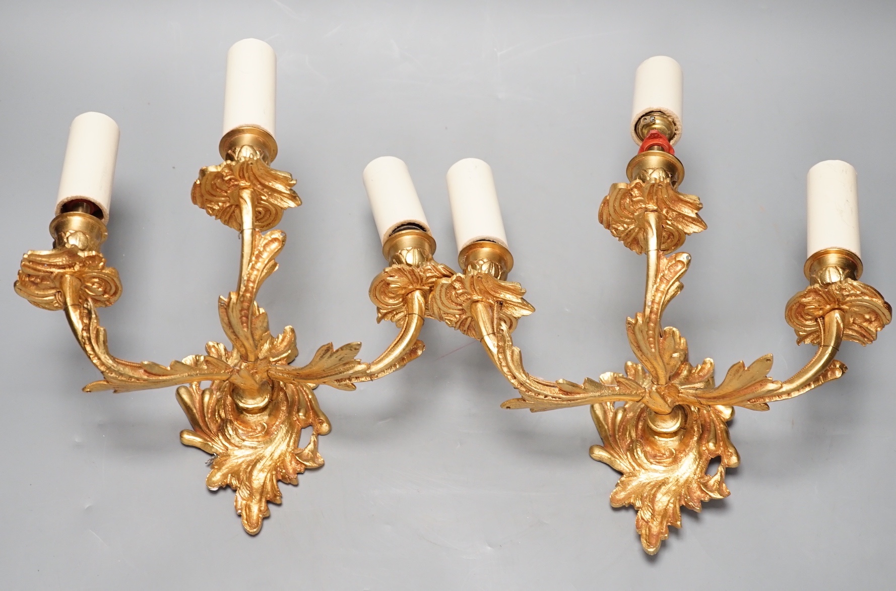 A pair of ormolu three branch wall lights